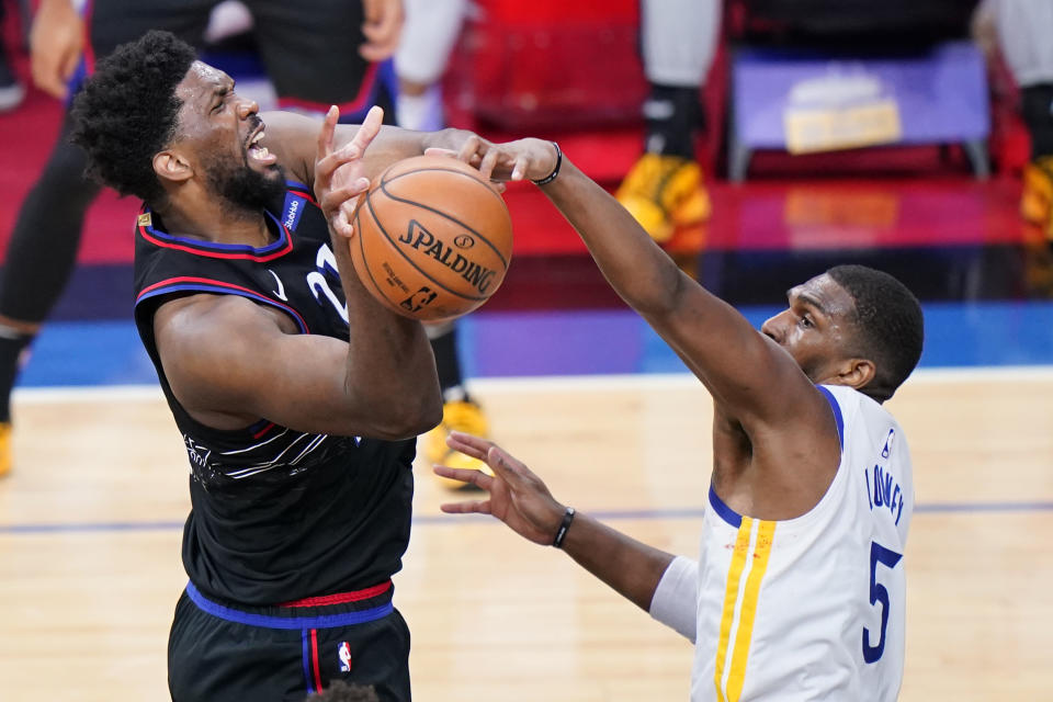 Golden State Warriors' Kevon Looney, right, blocks a shot by Philadelphia 76ers' Joel Embiid during the second half of an NBA basketball game, Monday, April 19, 2021, in Philadelphia. (AP Photo/Matt Slocum)