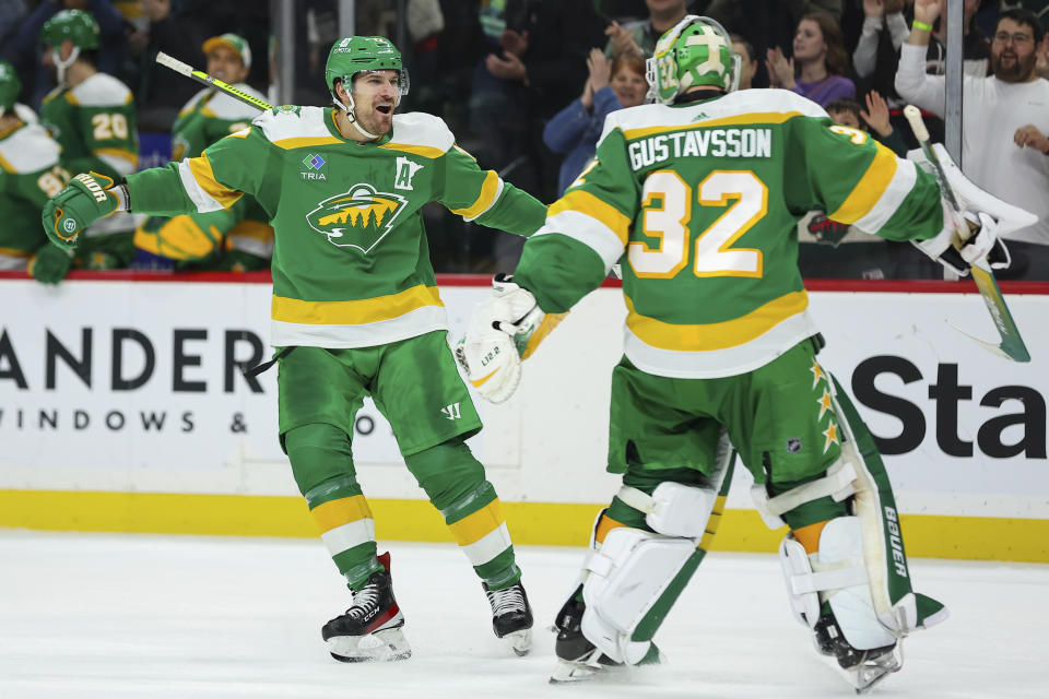 Minnesota Wild left wing Marcus Foligno (17) celebrates with goaltender Filip Gustavsson (32) following the teams shootout win against the Vancouver Canucks in an NHL hockey game Saturday, Dec. 16, 2023, in St Paul, Minn. (AP Photo/Matt Krohn)