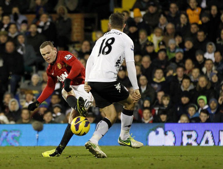 Manchester United's striker Wayne Rooney (L) scores past Fulham's defender Aaron Hughes during an English Premier League football match at Craven Cottage Stadium in London, England, on February 2, 2013. Manchester United overcame a floodlight failure to win 1-0 at Fulham through a late Rooney goal on Saturday as Alex Ferguson's side went 10 points clear at the top of the Premier League