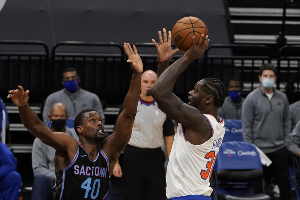 New York Knicks forward Julius Randle, right, shoots over Sacramento Kings forward Harrison Barnes, left, during the first quarter of an NBA basketball game in Sacramento, Calif., Friday, Jan. 22, 2021. (AP Photo/Rich Pedroncelli)