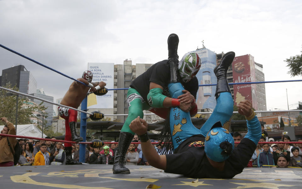 Mexican wrestler Rakner clashes with Relampago Veloz during "lucha libre" fight in Mexico City, Saturday, Dec. 21, 2019. Mexican wrestling, otherwise known as the “lucha libre,” is a highly traditional form of light entertainment. (AP Photo/Ginnette Riquelme)