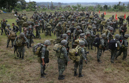 Members of the Philippine Marine Battalion Landing Team (MBLT) and Marine Special Operations Group (MARSOG) carry their belongings during their send-off ceremony ending their combat duty against pro-Islamic State militant groups inside a military headquarters in Marawi city, southern Philippines October 21, 2017, a few days after President Rodrigo Duterte announced the liberation of Marawi city. REUTERS/Romeo Ranoco