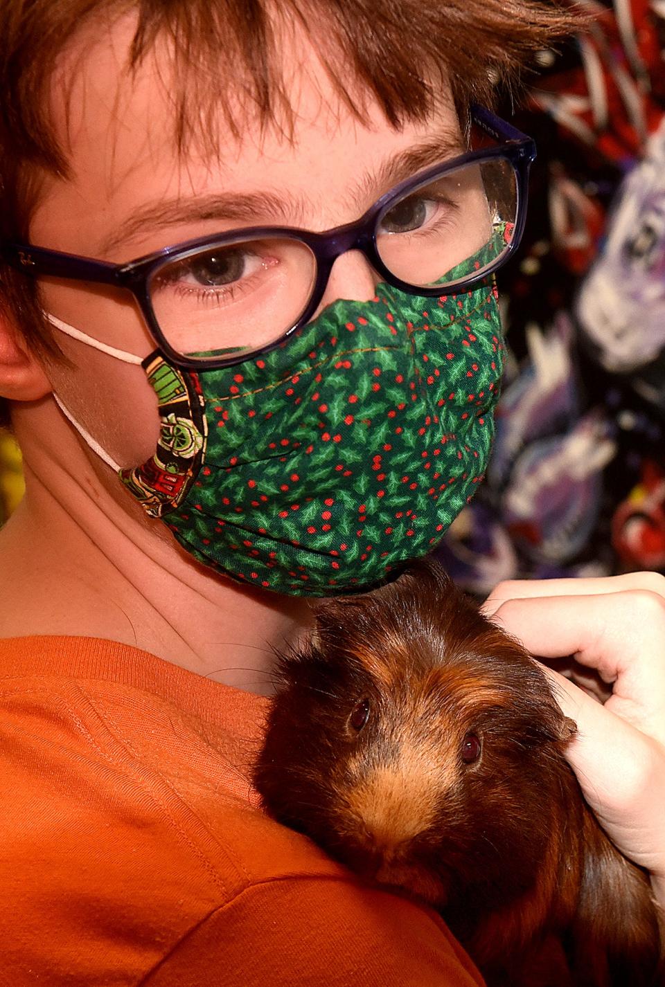 Kyven Emery, 11, a seventh grader at Jefferson Middle School, holds a guinea pig that lives at the Jefferson Middle School Zoo on Friday during the morning feeding of the animals.