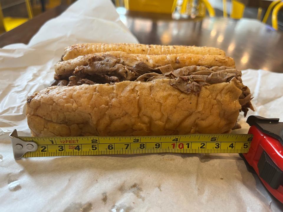 A tape measure next to an Al's Beef sandwich measuring 5 1/2 inches.
