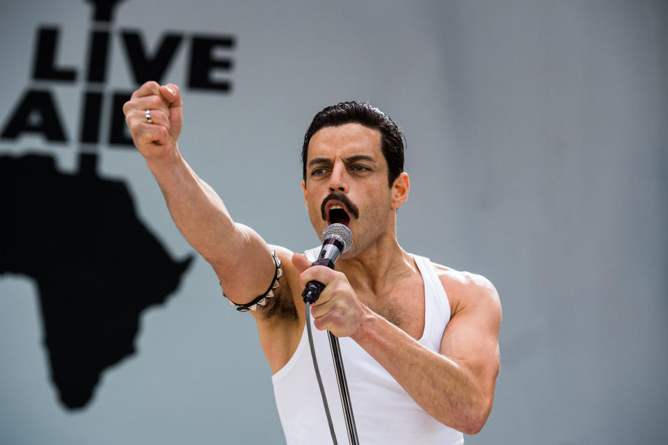 Rami Malek as Freddy Mercury throws a fist into the air at Live Aid