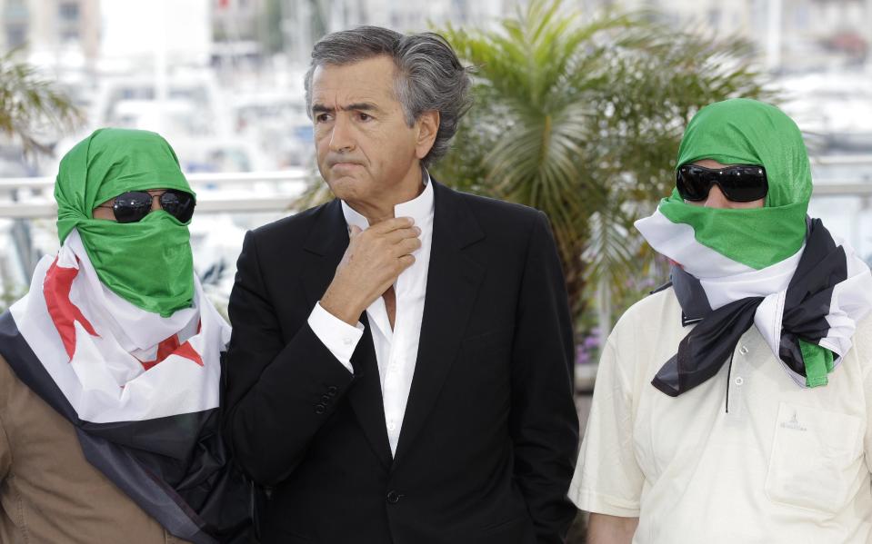 Director Bernard-Henry Levy, centre, flanked by two unidentified persons wearing Syrian flags pose during a photo call for The Oath of Tobruk at the 65th international film festival, in Cannes, southern France, Friday, May 25, 2012. (AP Photo/Lionel Cironneau)