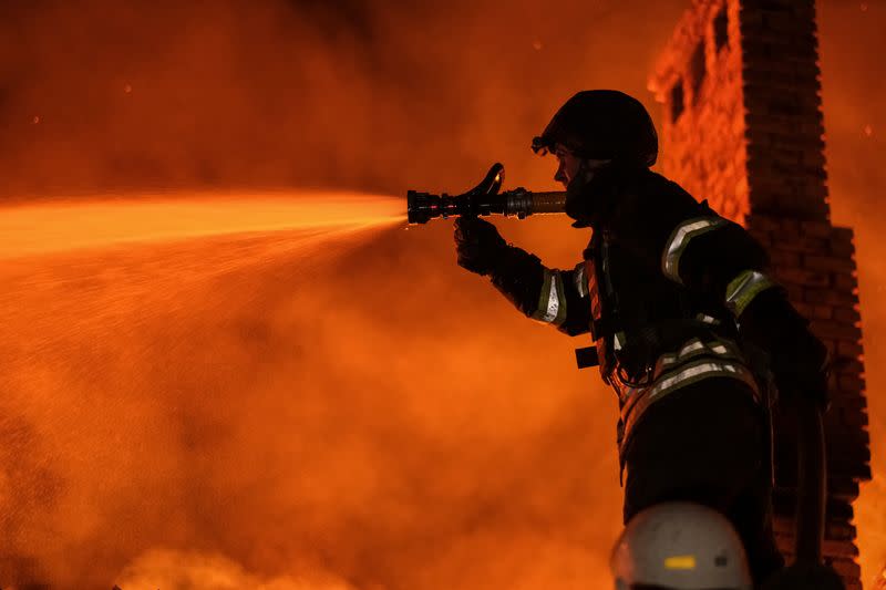 Bomberos ucranianos apagan el fuego en una casa residencial después de un ataque militar ruso. en Bajmut