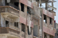 A man throws out debris from an apartment building in Douma, outside Damascus, Syria, September 17, 2018. REUTERS/Marko Djurica/Files