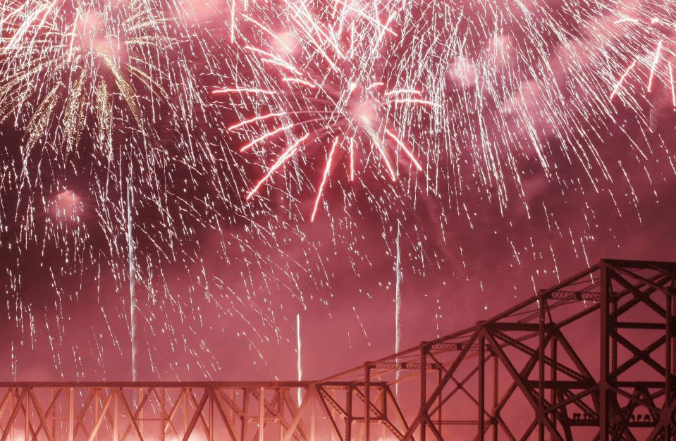 The Second Street Bridge was bathed in red from a flurry of bursting fireworks. 