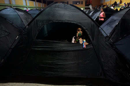 A woman sits inside a tent at the municipal coliseum after the Colombian government ordered the evacuation of residents living along the Cauca river, as construction problems at a hydroelectric dam prompted fears of massive flooding, in Valdivia, Colombia May 17, 2018. REUTERS/Fredy Builes