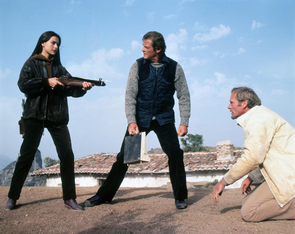 French actress Carole Bouquet, British actors Roger Moore and Julian Glover on the set of For Your Eyes Only, directed by John Glen. (Photo by Sunset Boulevard/Corbis via Getty Images)