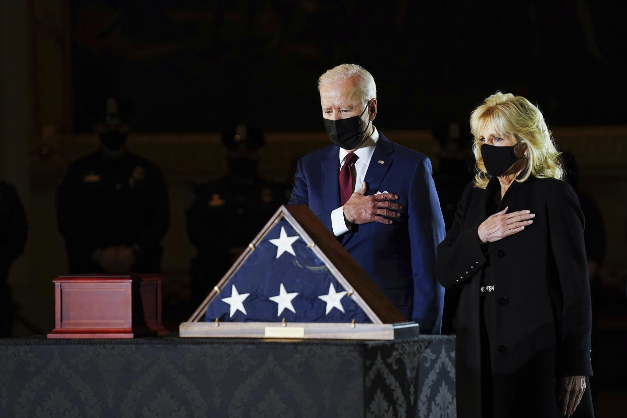 President Joe Biden and first lady Jill Biden pay their respects to the late U.S. Capitol Police officer Brian Sicknick as an urn with his cremated remains lies in honor on a black-draped table at center of Capitol Rotunda, Tuesday, Feb. 2, 2021, in Washington. (Erin Schaff/The New York Times via AP, Pool)