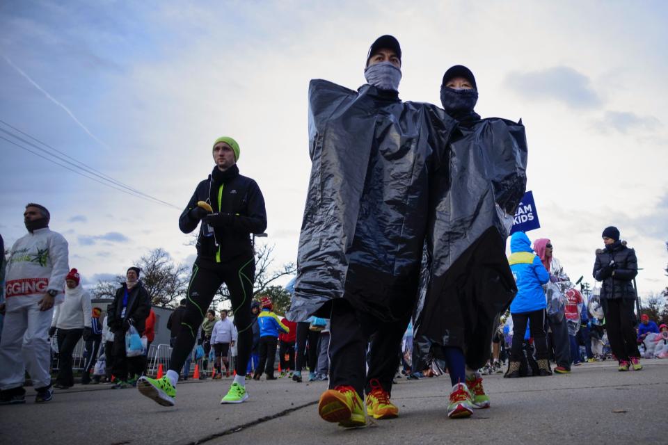 Runners cover themselves from the low temperatures and strong wind before the start of the New York City Marathon in New York, November 2, 2014. REUTERS/Eduardo Munoz (UNITED STATES - Tags: SPORT ATHLETICS)