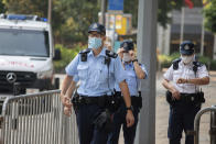 Police officers walk as they wait for Tong Ying-kit's arrival outside a court in Hong Kong Tuesday, July 27, 2021. Tong, 24, the first person to be tried under Hong Kong's sweeping national security law was found guilty of secessionism and terrorism on Tuesday in a ruling condemned by human rights activists. (AP Photo/Matthew Cheng)