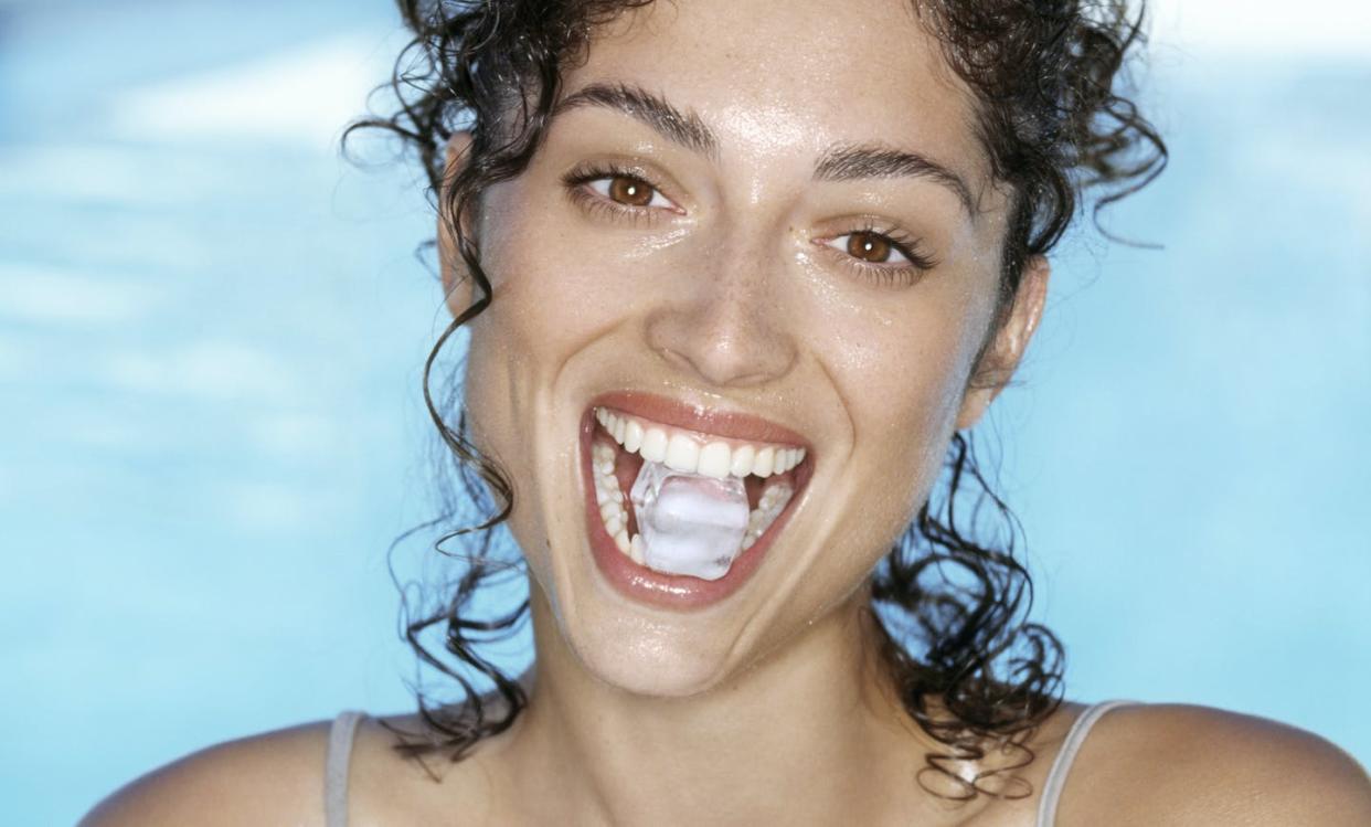 <span class="caption">Your teeth will be better off if you refrain from chomping on ice cubes. </span> <span class="attribution"><a class="link " href="https://www.gettyimages.com/detail/photo/young-woman-holding-ice-cube-in-teeth-smiling-royalty-free-image/200184731-001" rel="nofollow noopener" target="_blank" data-ylk="slk:Credit: Laurence Monneret/The Image Bank via Getty Images;elm:context_link;itc:0;sec:content-canvas">Credit: Laurence Monneret/The Image Bank via Getty Images</a></span>