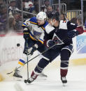 St. Louis Blues right wing Alexey Toropchenko, back, fights for control of the puck with Colorado Avalanche defenseman Erik Johnson in the second period of an NHL hockey game Saturday, Jan. 28, 2023, in Denver. (AP Photo/David Zalubowski)