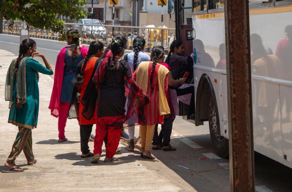 A group of women boarding a Foxconn factory bus in Molachur, Tamil Nadu, India on April 1, 2024. REUTERS