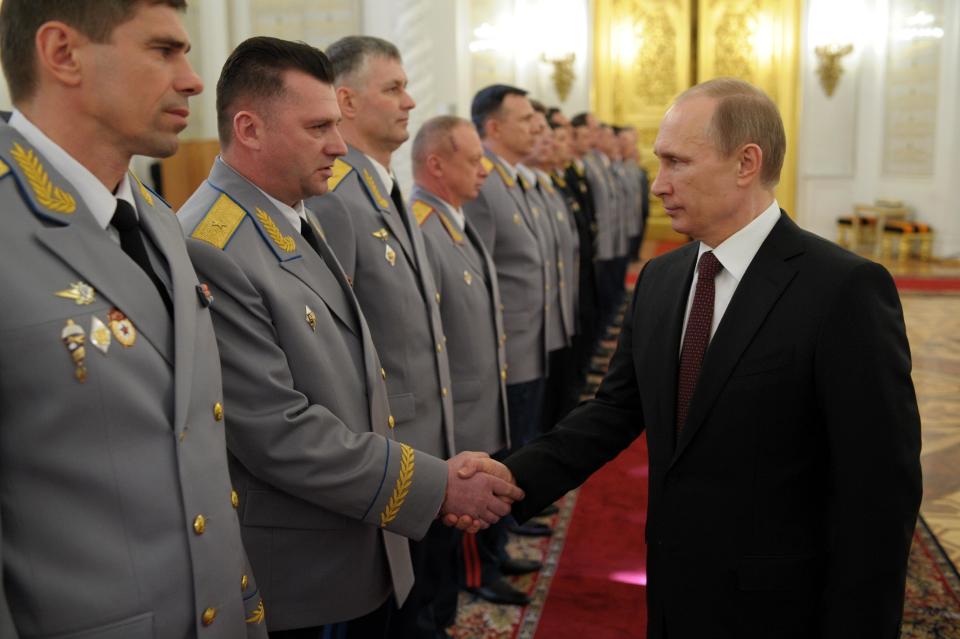 Russian President Vladimir Putin, right, shakes hands at the presentation ceremony of the top military brass in the Kremlin in Moscow, Russia, Friday, March 28, 2014. Russia's president says Ukraine could regain some arms and equipment of military units in Crimea that did not switch their loyalty to Russia. (AP Photo/RIA-Novosti, Alexei Druzhinin, Presidential Press Service)