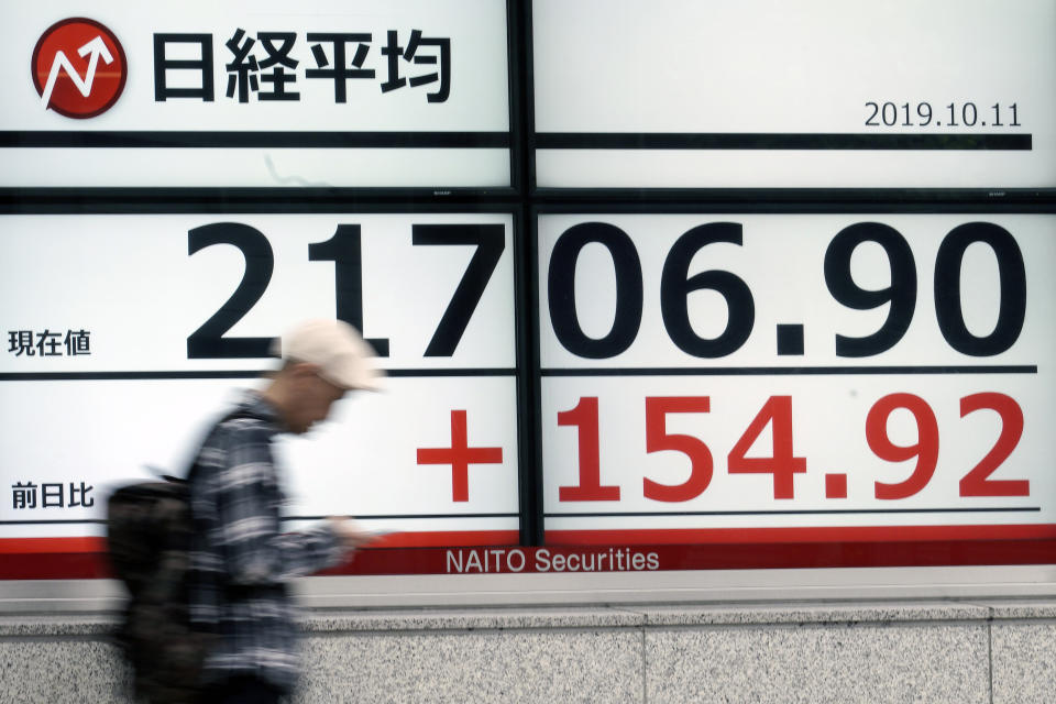 A man walks past an electronic stock board showing Japan's Nikkei 225 index at a securities firm in Tokyo Friday, Oct. 11, 2019. Asian stock markets followed Wall Street higher Friday on optimism about U.S.-Chinese talks on ending a tariff war.(AP Photo/Eugene Hoshiko)