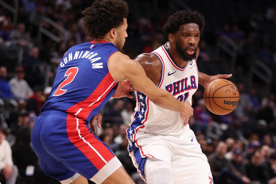 76ers center Joel Embiid drives around Pistons guard Cade Cunningham during the first half of the Pistons' 129-111 loss on Wednesday, Dec. 13, 2023, at Little Caesars Arena.