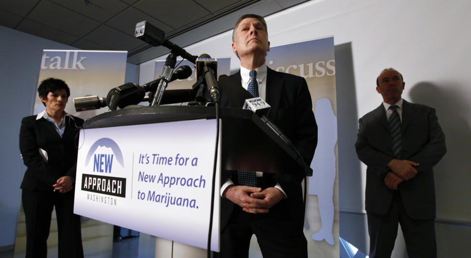 FILE - In this Wednesday, June 22, 2011 file photo, Seattle City Attorney Peter Holmes, center, is flanked by campaign director Alison Holcomb, left, and Mark Johnson during a news conference announcing the filing of an initiative to legalize possession of marijuana in Washington state in Seattle. I-502 would legalize up to an ounce of marijuana and create a system of state-licensed growers, processors and retail stores. It was tailored to gain mainstream support: There would be no home-growing, but there would be a DUI standard designed to be comparable to the 0.08 limit for blood-alcohol content. (AP Photo/Elaine Thompson, File)