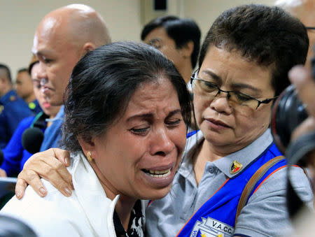Lorenza Delos Santos, 43, mother of 17-year-old high school student Kian delos Santos who was killed in a recent war on drugs police raid, cries as she is comforted by a member of the Volunteers Against Crimes and Corruption (VACC) during a hearing at the Senate headquarters in Pasay city, metro Manila, Philippines August 24, 2017. REUTERS/Romeo Ranoco