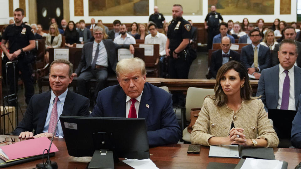 Former President Donald Trump, center, sits in the courtroom with his legal team, including attorney Alina Habba, right, before the start of his civil business fraud trial, Wednesday, Oct. 4, 2023, at New York Supreme Court in New York. (AP Photo/Mary Altaffer, POOL)