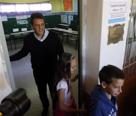 Sergio Massa, mayor of Buenos Aires' Tigre, accompanied by his children Milagros and Tomas (R) prepares to vote for the legislative election in Tigre October 27, 2013. REUTERS/Enrique Marcarian