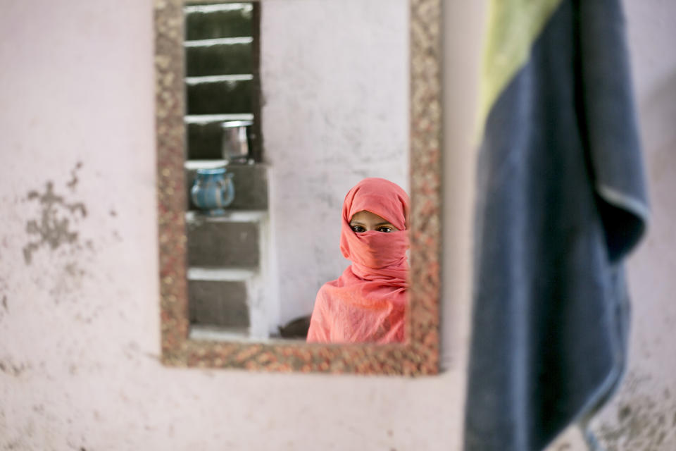 UTTAR PRADESH, INDIA - SEPTEMBER 8:  8 year old Sadaf (name changed) stands for a photo on September 8, 2016 in Uttar Pradesh, India. 3 months ago she was raped by a doctor in her village. She was walking to the market to buy sweets when the doctor, who her family estimates is around 50 years old, forcefully pulled her inside his clinic and raped her. Afterwards she stumbled out onto the street and fainted. When her family found her she was covered in blood and profusely bleeding. She told them what happened and they went to the police but the police refused to register a case, they said that they should compromise because the doctor was offering them 2 lakh rupees (around $2,989) to drop the case. The family refused, and says 'They destroyed the life of our child, how can we compromise?'. They estimate that they and their neighbors had to go to the police station 10 times before the police agreed to register the case. For 5 days after the rape, Sadaf bled and they had to shuffle from hospital to hospital looking for a hospital that had facilities that could provide adequate care for her. Since the rape Sadaf has been sick and week and is too afraid to leave the house or return to school. The family is also afraid to let her leave the house because they say the rapist comes from a rich and powerful family and could harm her or kidnap her. Before the rape she enjoyed going to school and dreamed of being an English teacher when she grows up. She loved to play board games and cricket with her best friend, Nisha, but she hasn't seen her for 3 months. Sadaf's uncle, who is fighting the case, has taken out two loans to help pay for transportation to the court house and for lawyer bills. Every time he has to go to court he must take off work from his job as a day laborer. (Photo by Getty Images)