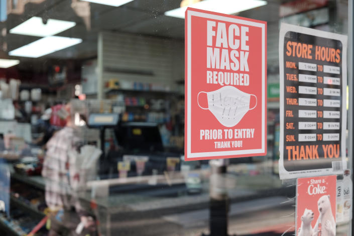 A sign on the door of a store reads: Face Mask Required Prior to Entry.