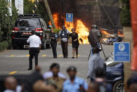 <p> Security forces help civilians flee the scene as cars burn behind, at a hotel complex in Nairobi, Kenya Tuesday, Jan. 15, 2019. Terrorists attacked an upscale hotel complex in Kenya's capital Tuesday, sending people fleeing in panic as explosions and heavy gunfire reverberated through the neighborhood. (AP Photo/Ben Curtis) </p>