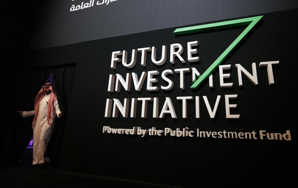 A Saudi participant walks in front of a banner for the Future Investment Initiative conference, in Riyadh, Saudi Arabia, Wednesday, Oct. 24, 2018. Saudi Crown Prince Mohammed bin Salman on Wednesday will address an international investment summit in Riyadh, his first such comments since the killing earlier this month of Washington Post columnist Jamal Khashoggi at the Saudi Consulate in Istanbul. (AP Photo/Amr Nabil)