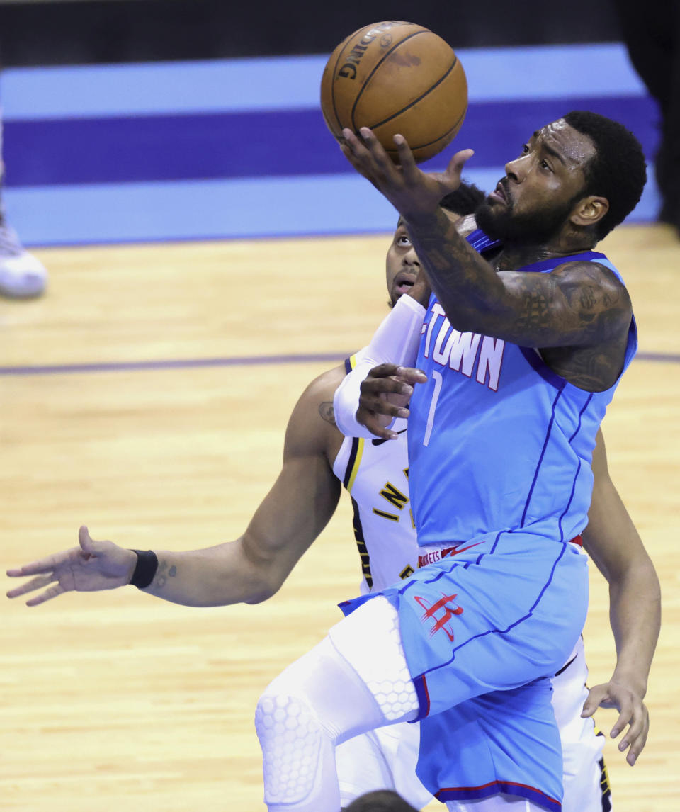 Houston Rockets' John Wall drives to the basket next to Indiana Pacers' Jeremy Lamb during the third quarter of an NBA basketball game Wednesday, April 14, 2021, in Houston. (Carmen Mandato/Pool Photo via AP)