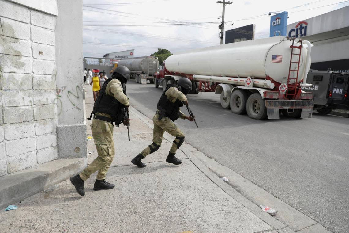 Police officers protect fuel trucks filled with gas as they drive from the Varreux fuel terminal, in Port-au-Prince, Haiti, Tuesday, Nov. 8, 2022. Trucks lined up at the fuel terminal to fill up their tanks for the first time since a powerful gang seized control of the area.