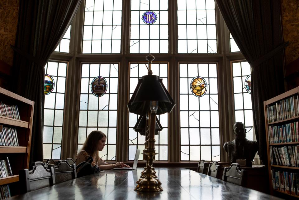 Diane Kollman, a book editor from Lithipolis, sits at a large table editing a book on her computer in the original library, which was built in 1925, at Wagnalls Memorial in Lithopolis, Ohio on August 22, 2022.