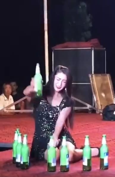 長髮女子瘋狂將酒瓶用力往舞台砸，敲完最後一瓶後，高舉酒瓶象徵表演結束。（圖／翻攝自 神北克 制作 漫畫工作室）