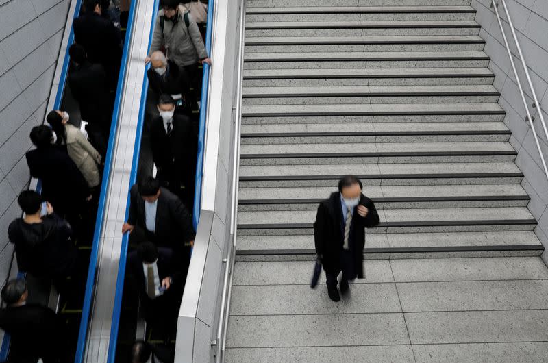 FILE PHOTO: Passengers wearing masks are seen at a train station in Tokyo, Japan