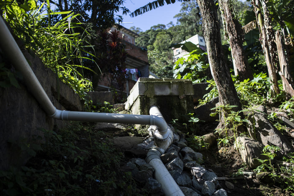 Pipes from the sewage treatment biosystem snake through the Enchanted Valley sustainable community on the outskirts of Tijuca National Forest in Rio de Janeiro, Brazil, Monday, June 6, 2022. Electricity arrived in the late 20th century to the low-income Enchanted Valley community, but the utility never connected it to the city’s sewage network, so its residents set out to solve the problem on its own by building a biodigester and artificial wetland to process all sewage generated by all of its 40 families. (AP Photo/Bruna Prado)