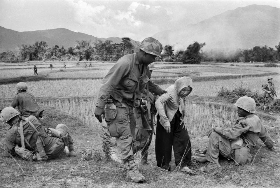 A U.S. air cavalryman helps an old Vietnamese woman up a hill, January 5, 1968. She had grown tired as she and her neighbours had to flee their village to a refugee camp. Other villagers had refused to assist her because, according to Vietnamese custom, they would then have borne responsibility for her for the remainder of her life. (AP Photo/Dang Van Phuoc)