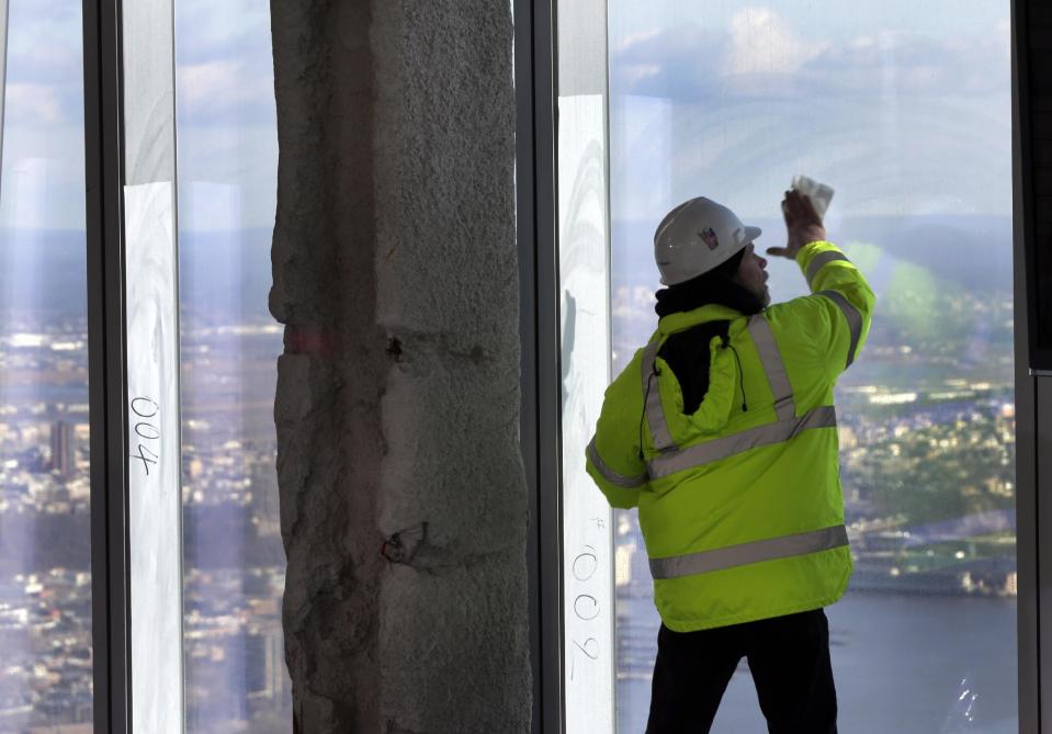 A Port Authority worker cleans a window of  the unfinished observation deck on the 100th floor of the One World Trade Center building, under construction in New York, Tuesday, April 2, 2013. The observation deck will occupy the tower's 100th through 102nd floors. Elevators will whisk visitors to the top in just one minute but the experience of visiting the attraction will take an hour. (AP Photo/Richard Drew)