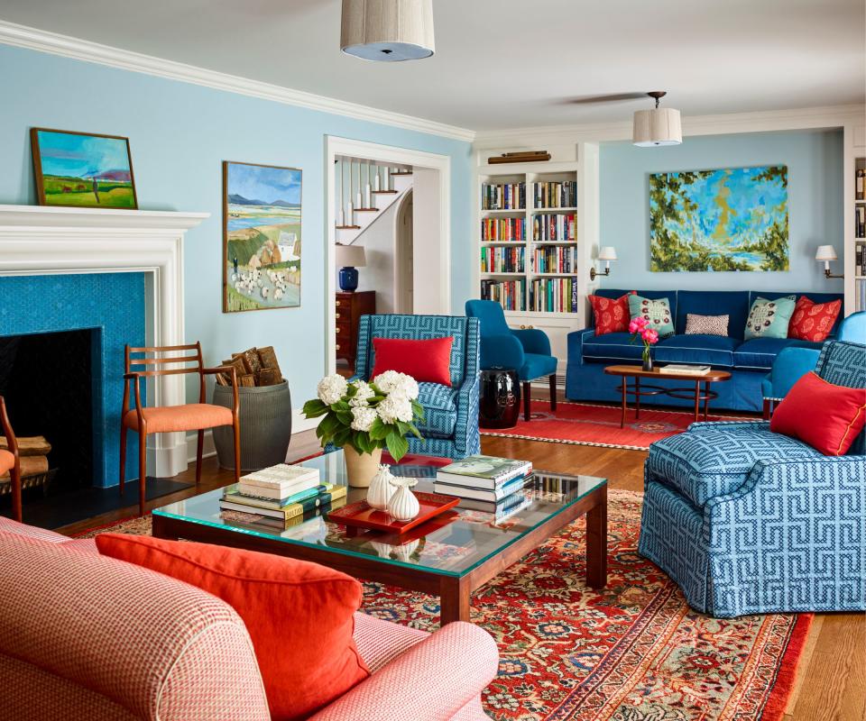 Blue sofas and armchairs, orange cushions, blue walls