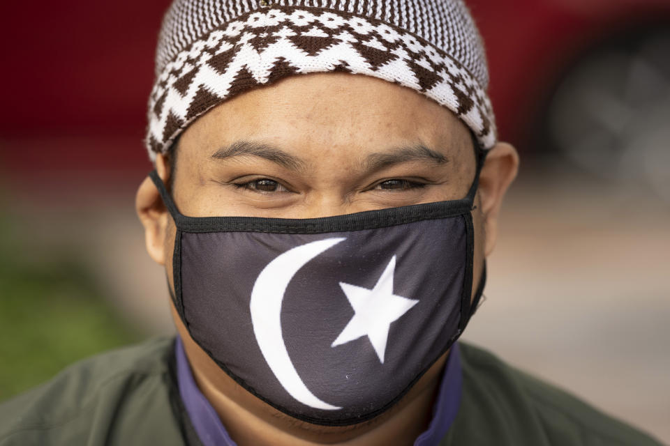 A Muslim man wearing a protective mask prepares to pray outside the closed National Mosque while celebrating Eid al-Fitr, the Muslim festival marking the end the holy fasting month of Ramadan, amid the coronavirus outbreak, in Kuala Lumpur, Malaysia, Sunday, May 24, 2020. (AP Photo/Vincent Thian)
