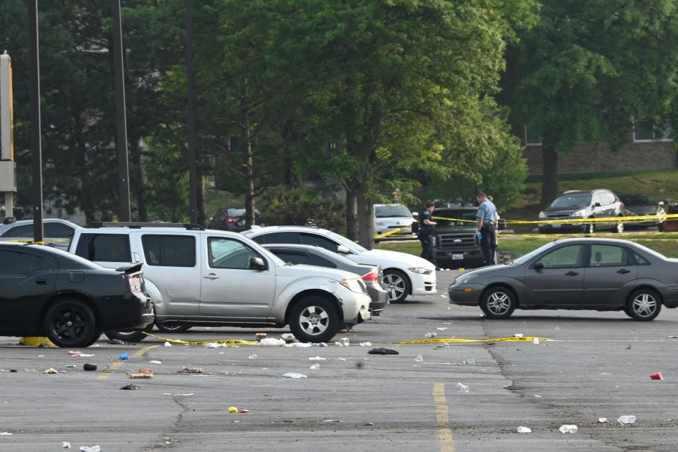 Investigators look over the scene of an overnight mass shooting at a strip mall in Willowbrook, Ill., Sunday, June 18, 2023. 