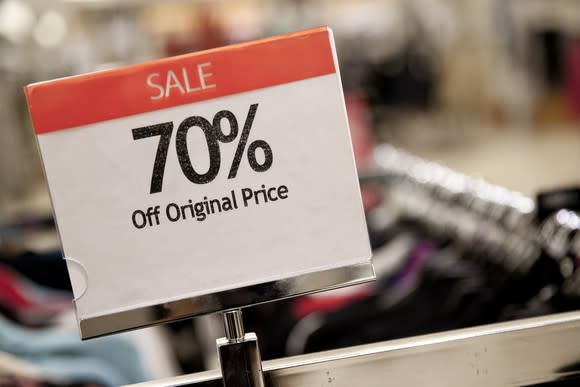 A sale sign for 70% off the original price of some clothes