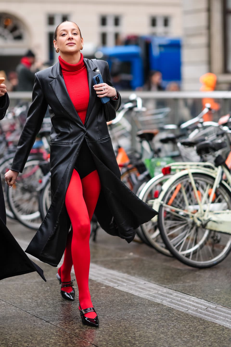 copenhagen, denmark january 30 a guest wears golde earrings, a red turtleneck pullover, a black leather long coat, red leggings, black leather shiny pointed shoes, outside aeron, during the copenhagen fashion week aw24 on january 30, 2024 in copenhagen, denmark photo by edward berthelotgetty images