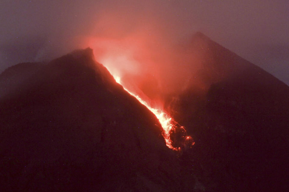 Lava flows down from the crater of Mount Merapi seen from Cangkringan village in Sleman, Yogyakarta, early Friday, March 11, 2022. Indonesia's Mount Merapi continued eruption Friday, forcing authorities to halt tourism and mining activities on its slopes because of the dangers on the country's most active volcano. (AP Photo/Slamet Riyadi)