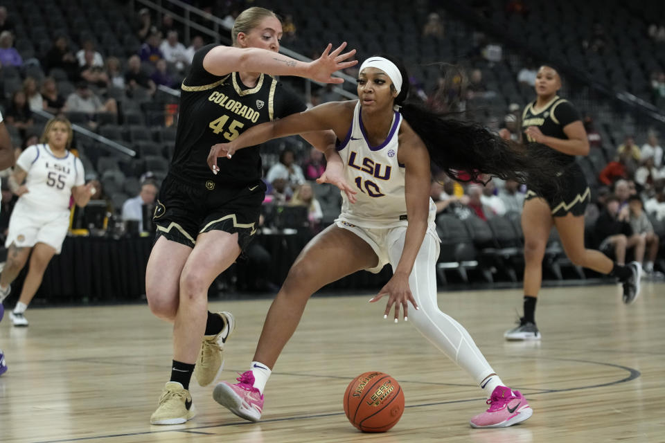 LSU forward Angel Reese (10) drives into Colorado forward Charlotte Whittaker (45) during the first half of an NCAA college basketball game Monday, Nov. 6, 2023, in Las Vegas. (AP Photo/John Locher)