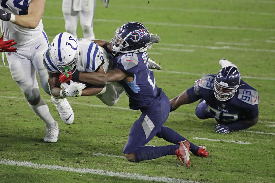 Indianapolis Colts running back Nyheim Hines, left, dives past Tennessee Titans cornerback Malcolm Butler, center, for a touchdown. (AP Photo/Ben Margot)