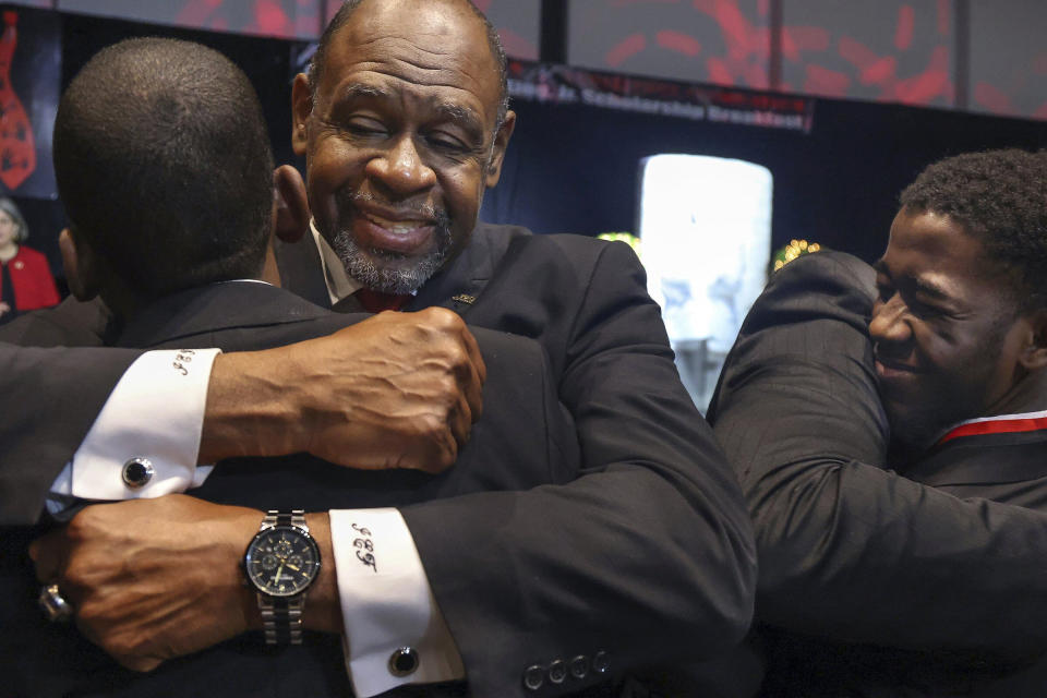 Miami-Dade Public schools educator Ira Fluitt, center, embraces student Andre Jackson, right, after being recognized as one of the 49 Wilson Scholars for Class of 2023, during the Annual Dr. Martin Luther King, Jr. Scholarship Breakfast on Monday, Jan. 16, 2023, at the Miami Beach Convention Center. The 5000 Role Models of Excellence Project celebrated its 30th Anniversary with a keynote address by Douglas Emhoff, the second gentleman of the U.S., who is married to the first female vice president, as the organization honored 2023 Wilson Scholars, Philanthropic Mentors, and inducted Models of Excellence. (Carl Juste/Miami Herald via AP)