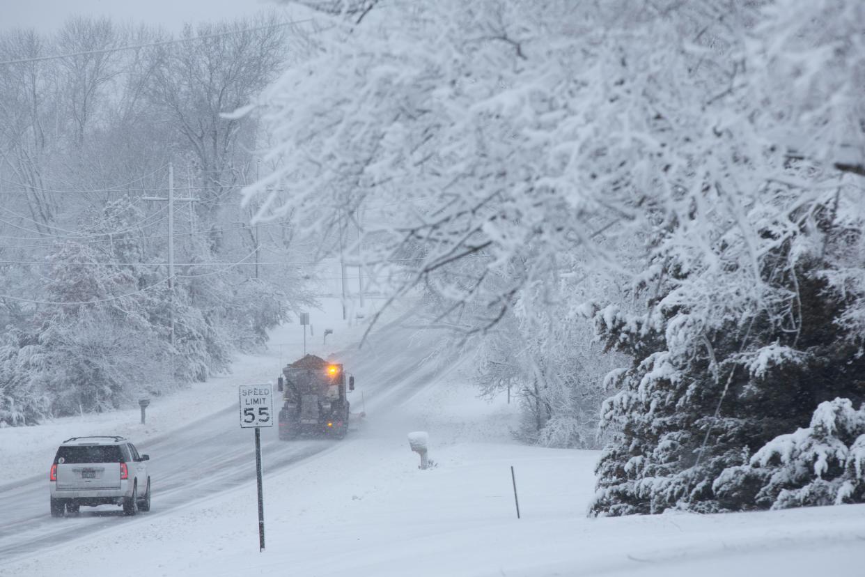 Traffic on N.E. 62nd. Street follows behind a Shawnee County snow plow as it clears away accumulated snow and distributes an anti-ice mix Tuesday morning.